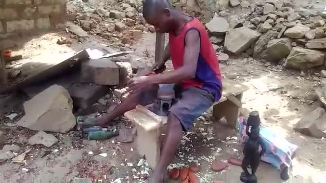 Blaise un sculpteur est entrain de fabriquer un panier de fruit, à Bangui